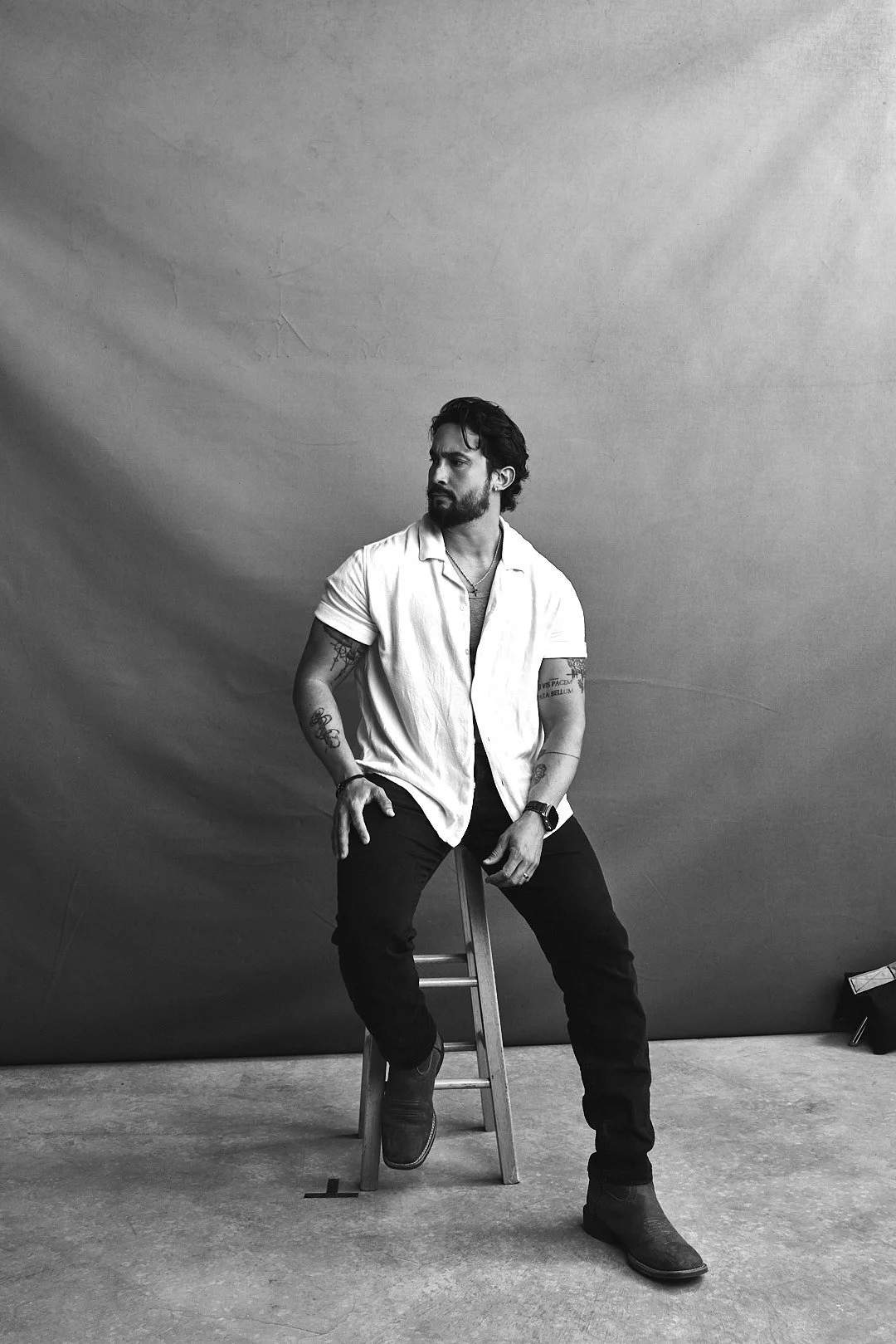 Black-and-white portrait of photographer Ale Sosa seated in his studio