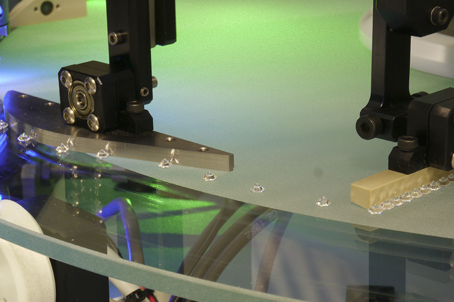 A distribution arm regulates the distance between two diamonds