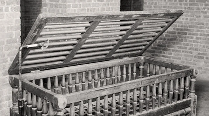 A confining bed that patients in a 19th-century asylum were caged in when they were unruly.