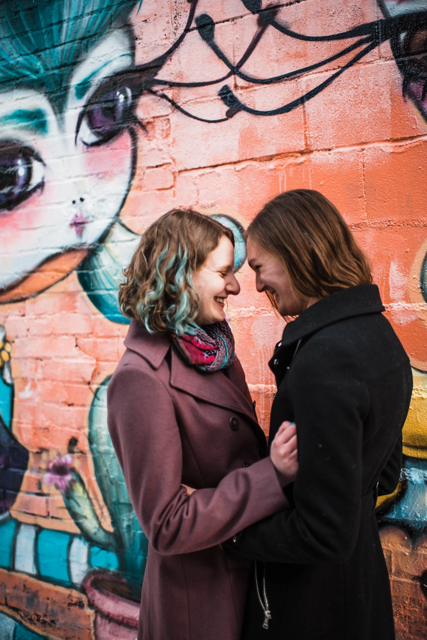 Same sex couple laughing, Denver Colorado RiNo art mural, RiNo Arts District, RiNo engagement session, LGBT wedding photographers, LGBT friendly wedding photographers, LGBT engagement photographers, Denver wedding photographers, Denver Engagement photographers