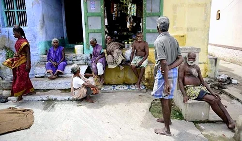 A group of elders gather outside a village corner shop. At times thalaikoothal is practiced even with their consent