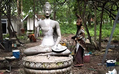 Sorceror by statue of buddha