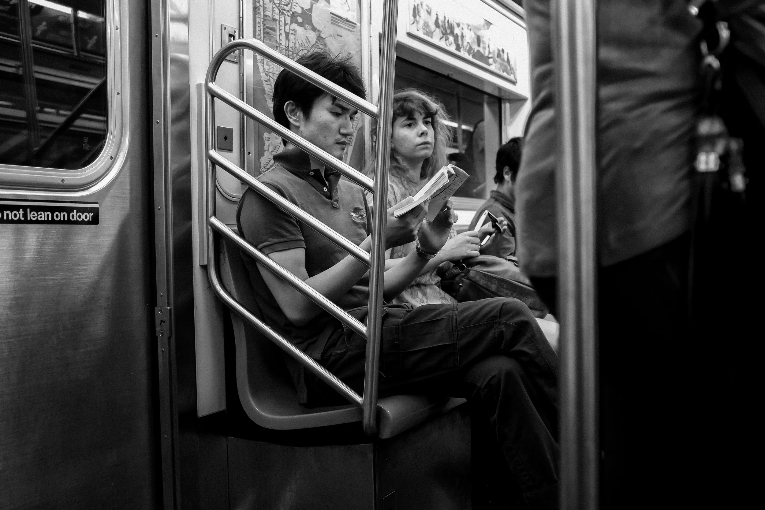  A commuter on a subway reads a book. 
