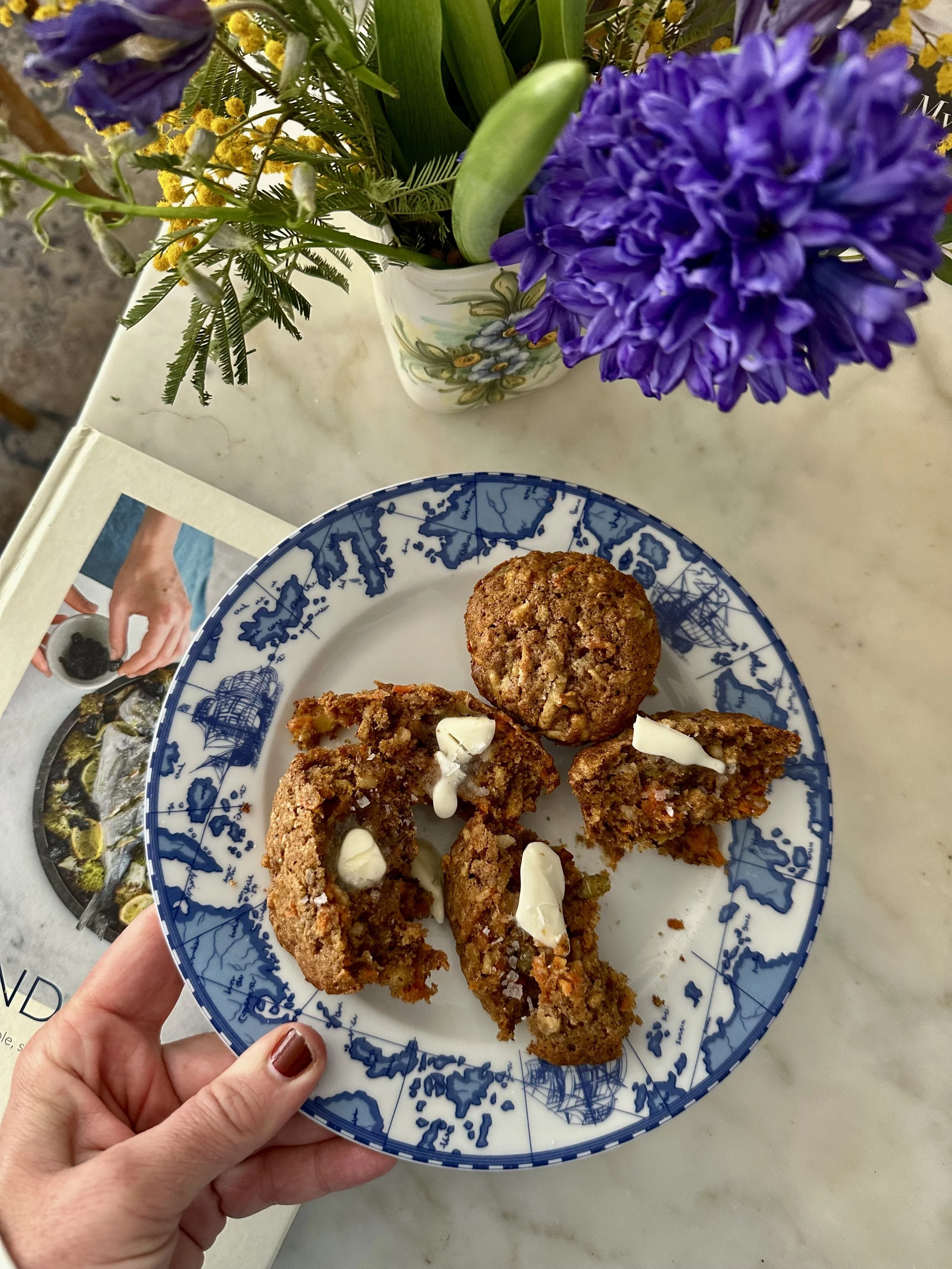 Everything from the pantry Muffins plated on a blue and white plate with a slathering of unsalted butter and a sprinkle of our sea salt on top.