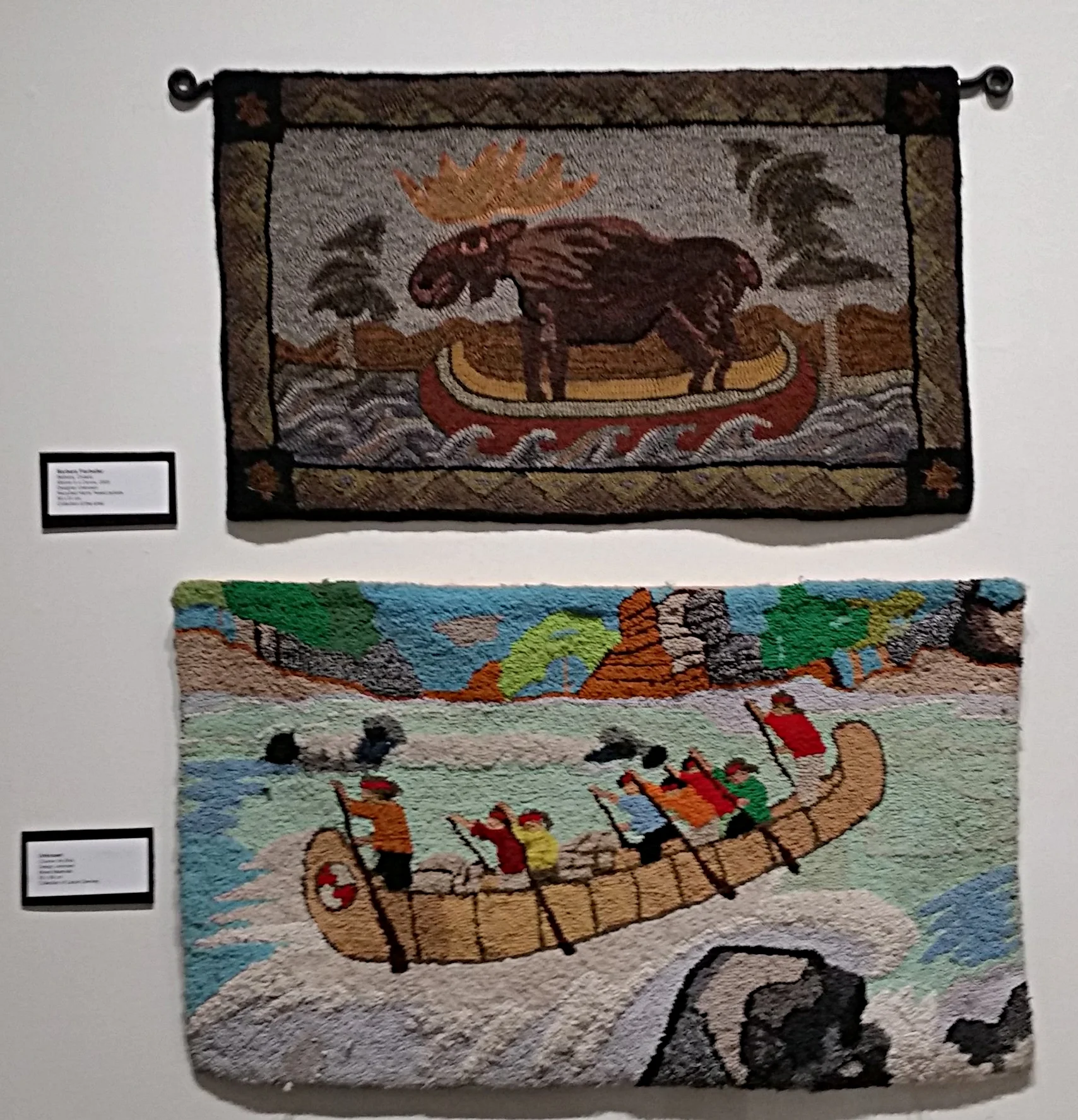 Some of the modern rugs on display. Top: Moose in a Canoe, Barbara Fierheller. From the collection of the artist. Bottom: Coureur de Bois. Artist unknown. From the collection of Laurie Deviney.