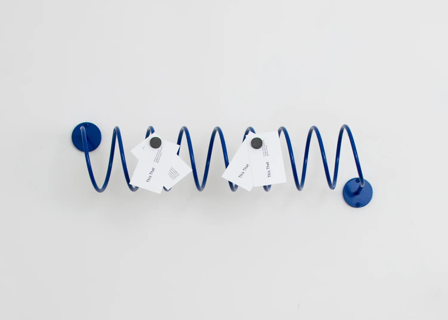 This That's Corkscrew Wall Hook holding paper with magnets.