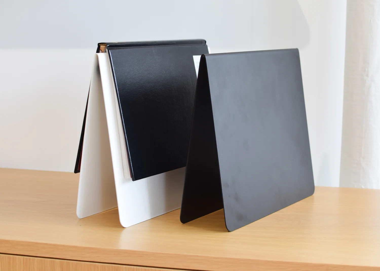 Copy of This That's Upright Bookmark in black holding a hardcover book.