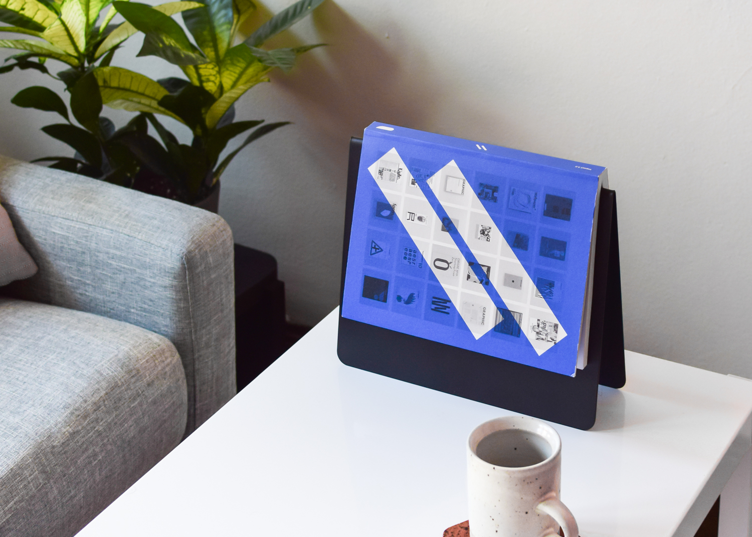 Copy of This That's Upright Bookmark holding a graphic design book.