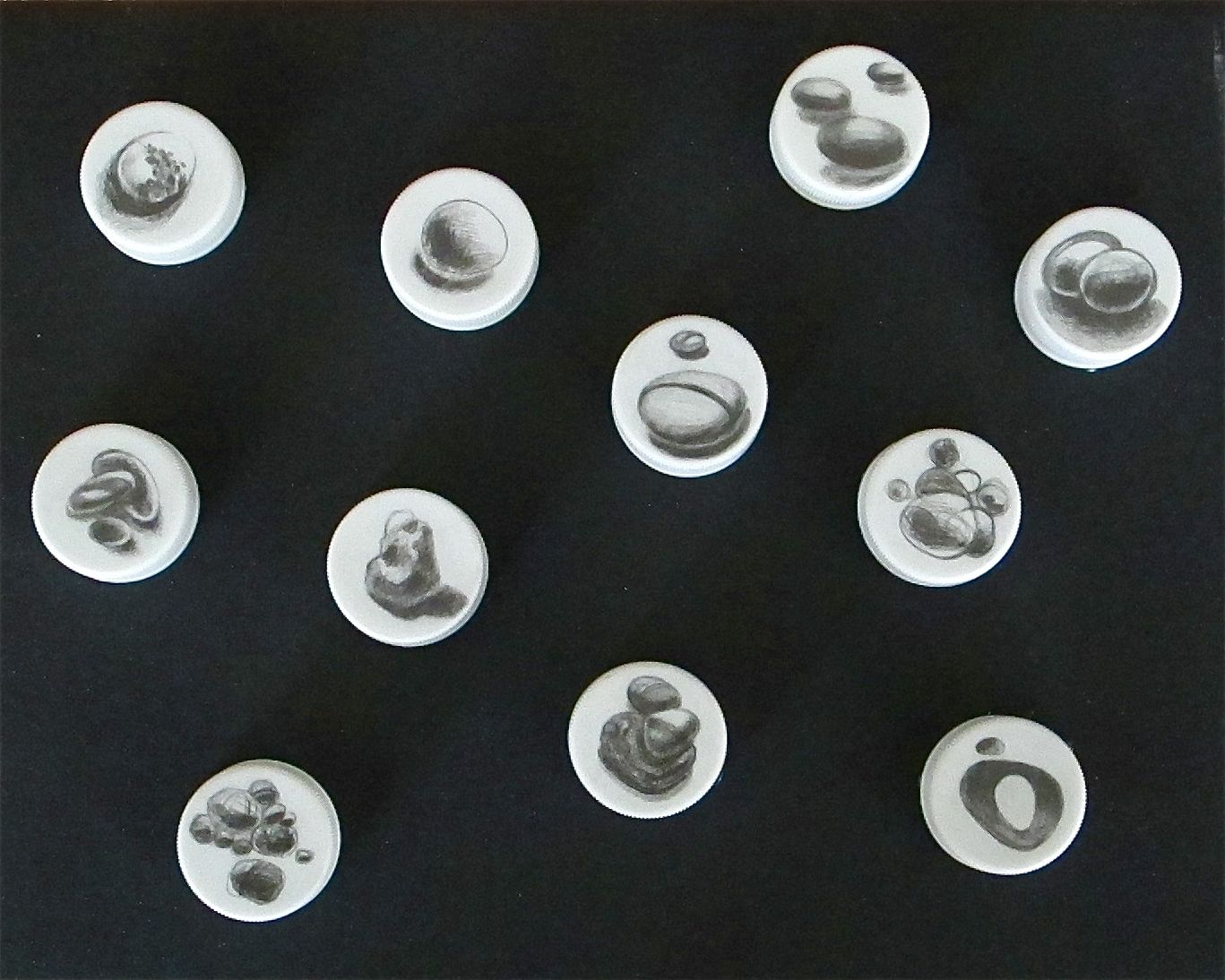    Commonalities, (Left)  , 2010 Graphite on Bottle Caps 11” x 9” shadow box 