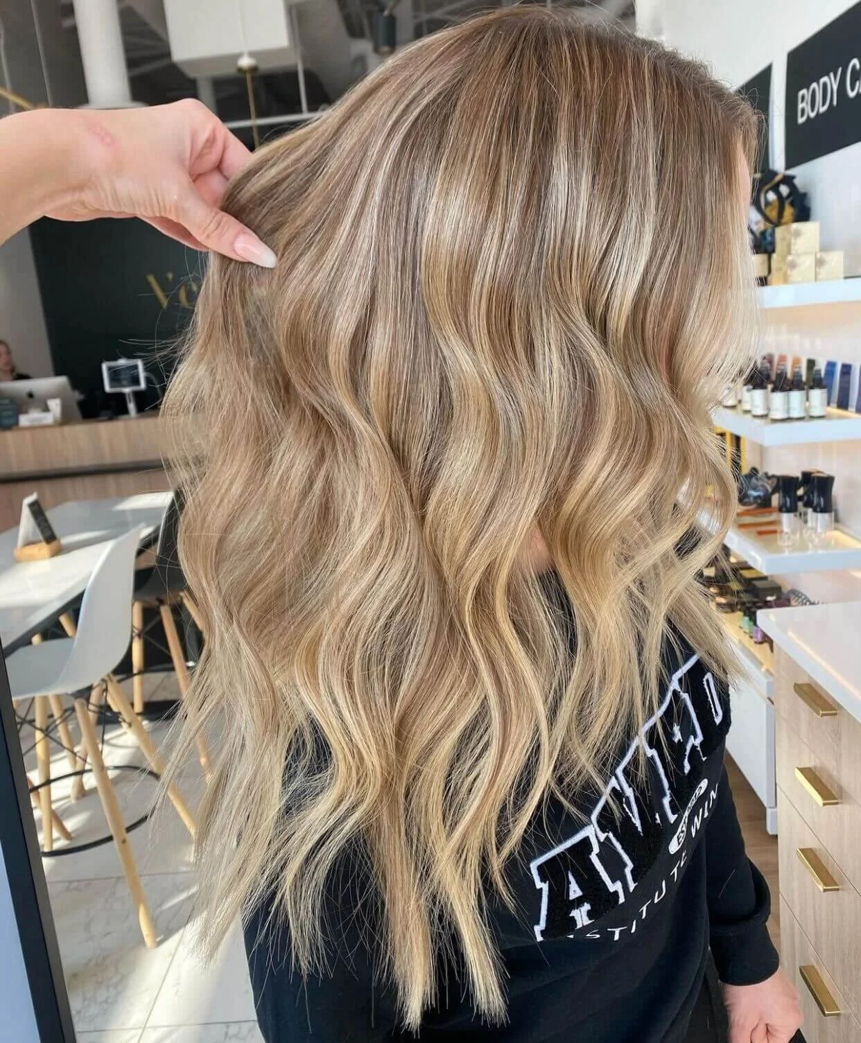 Close-up view of a woman with long, wavy blonde hair in a salon
