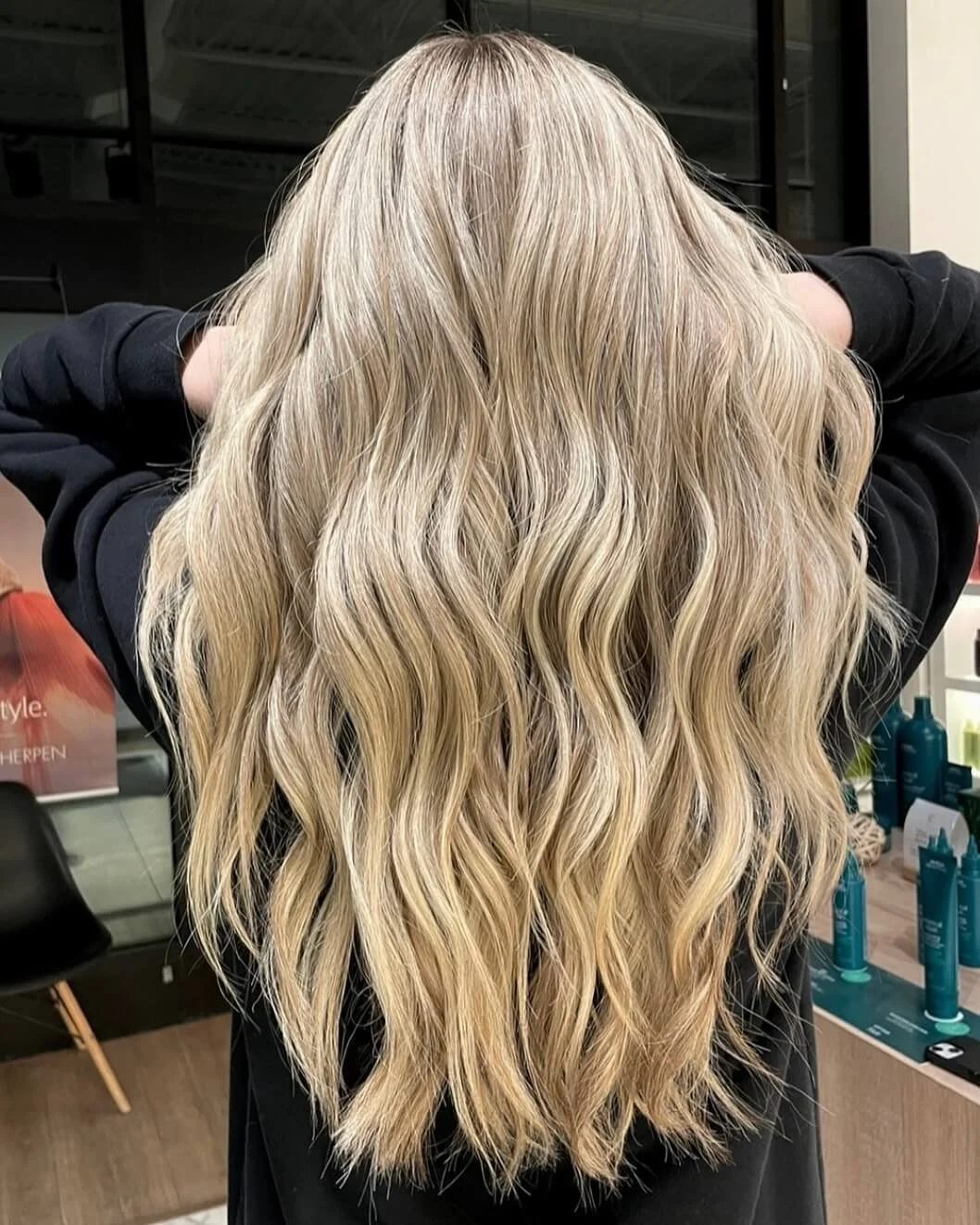 Back of a person with long, wavy, blonde hair.
