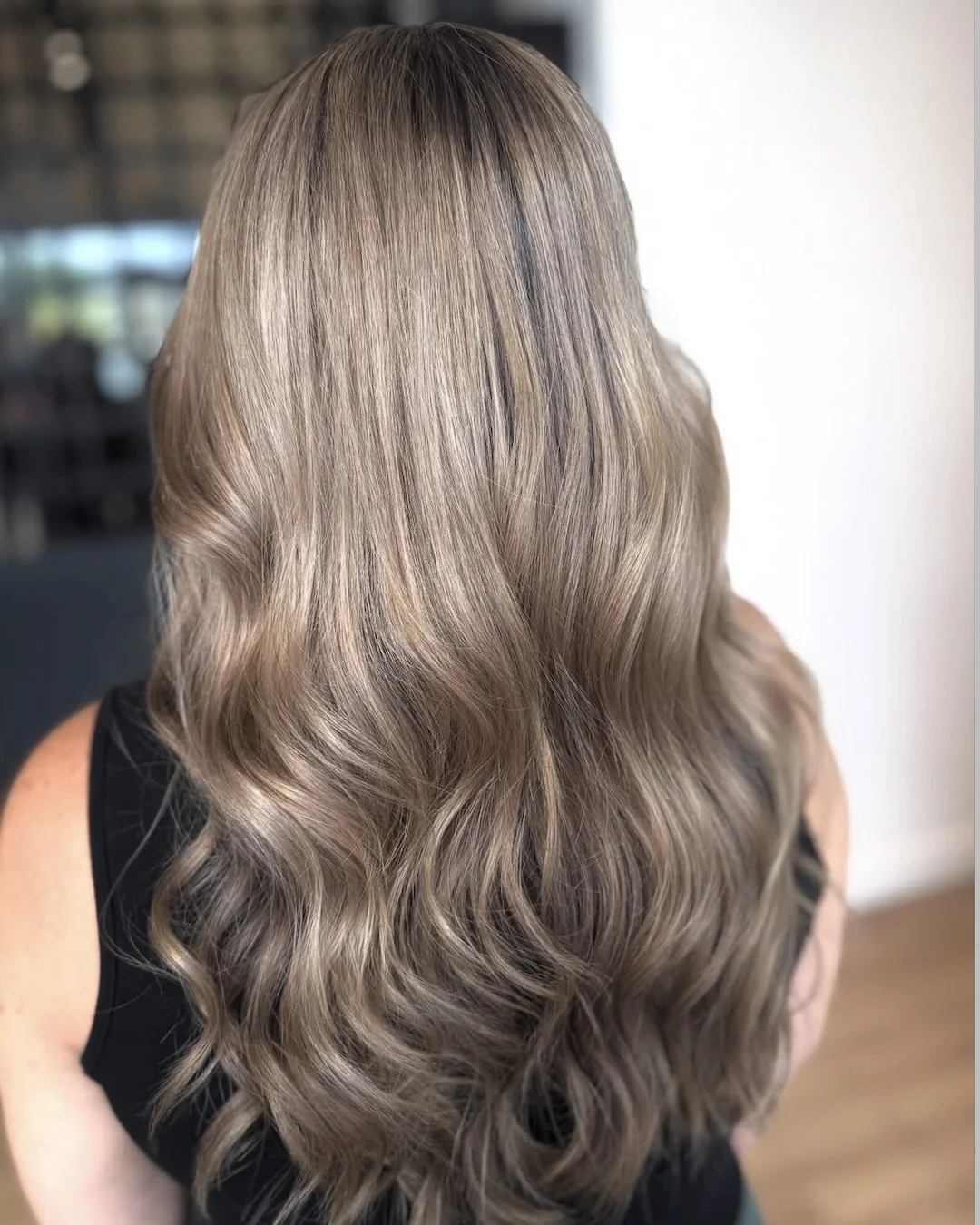 A woman with shoulder-length, wavy, light brown hair with subtle highlights.