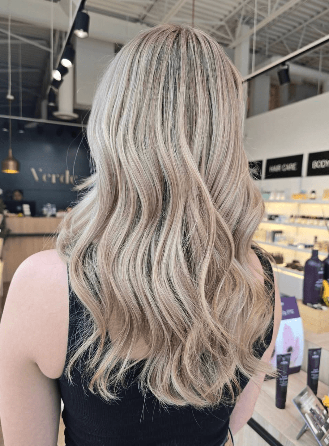 A woman with long, wavy blonde hair in a salon.