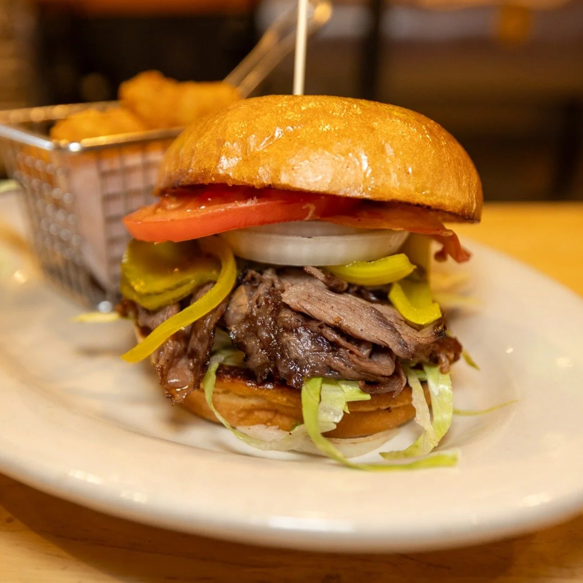 Try our Smoked Short Rib Sandwich
Made with shaved wagyu beef short rib, bread + butter pickles, shredded lettuce, tomato, onion, mayo on a grilled bun, housemade Kansas City bbq + South Carolina mustard sauce on the side, and your choice of side- se