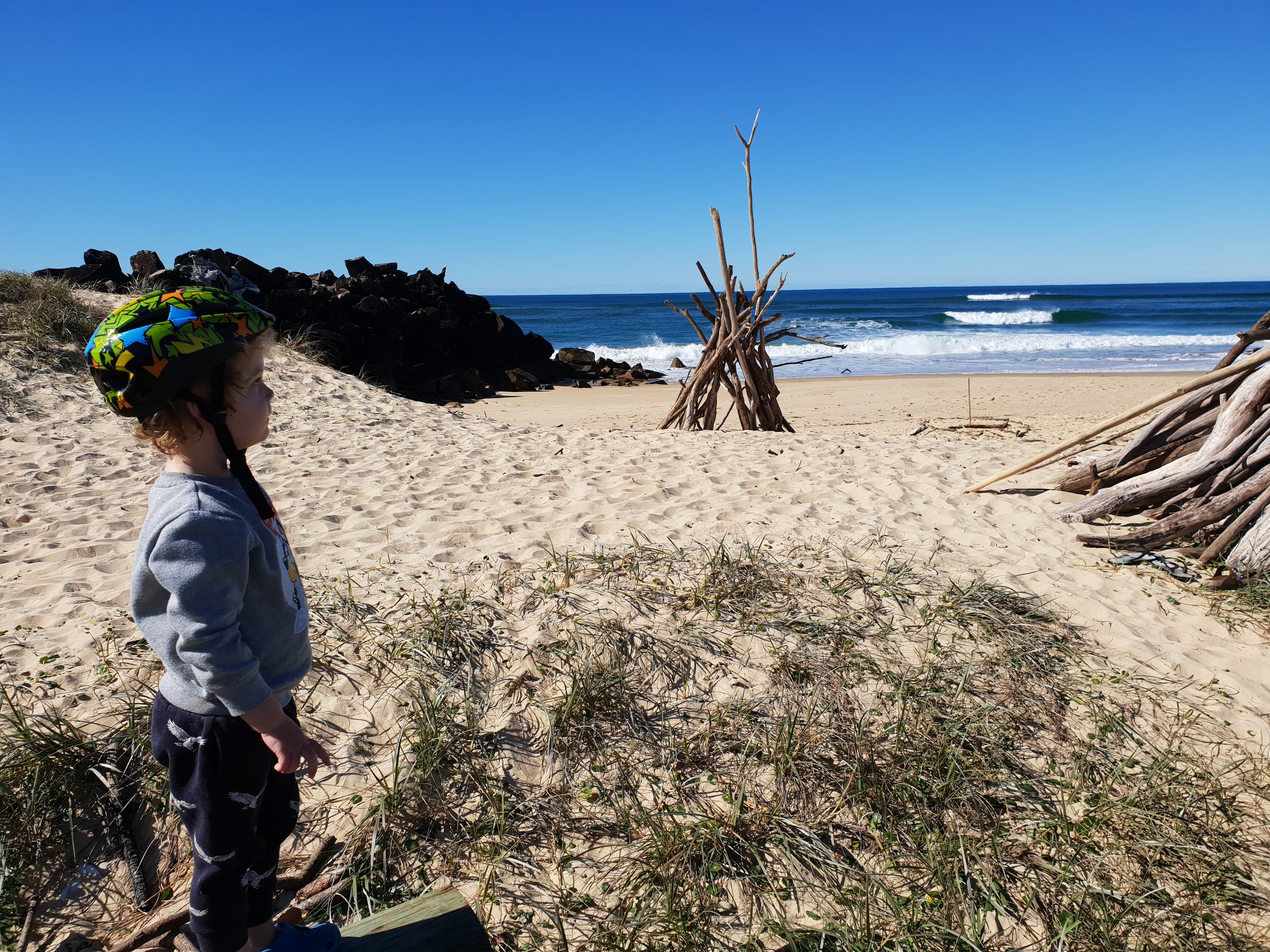Exploring a new beach with driftwood huts