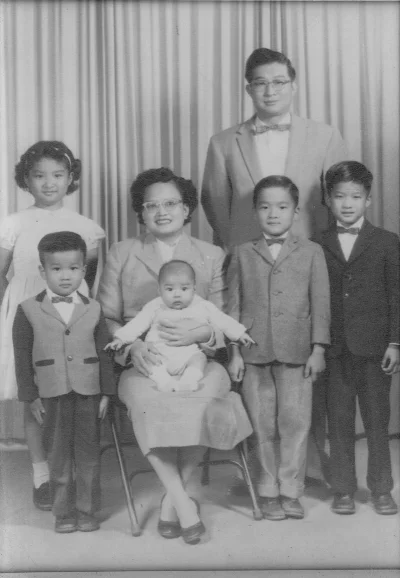 My dad is one with the prominent forehead on the left. This photo features Joyce and Morris along with their children, Betty, Wilson, Nixon, Newton, and David (L-R)