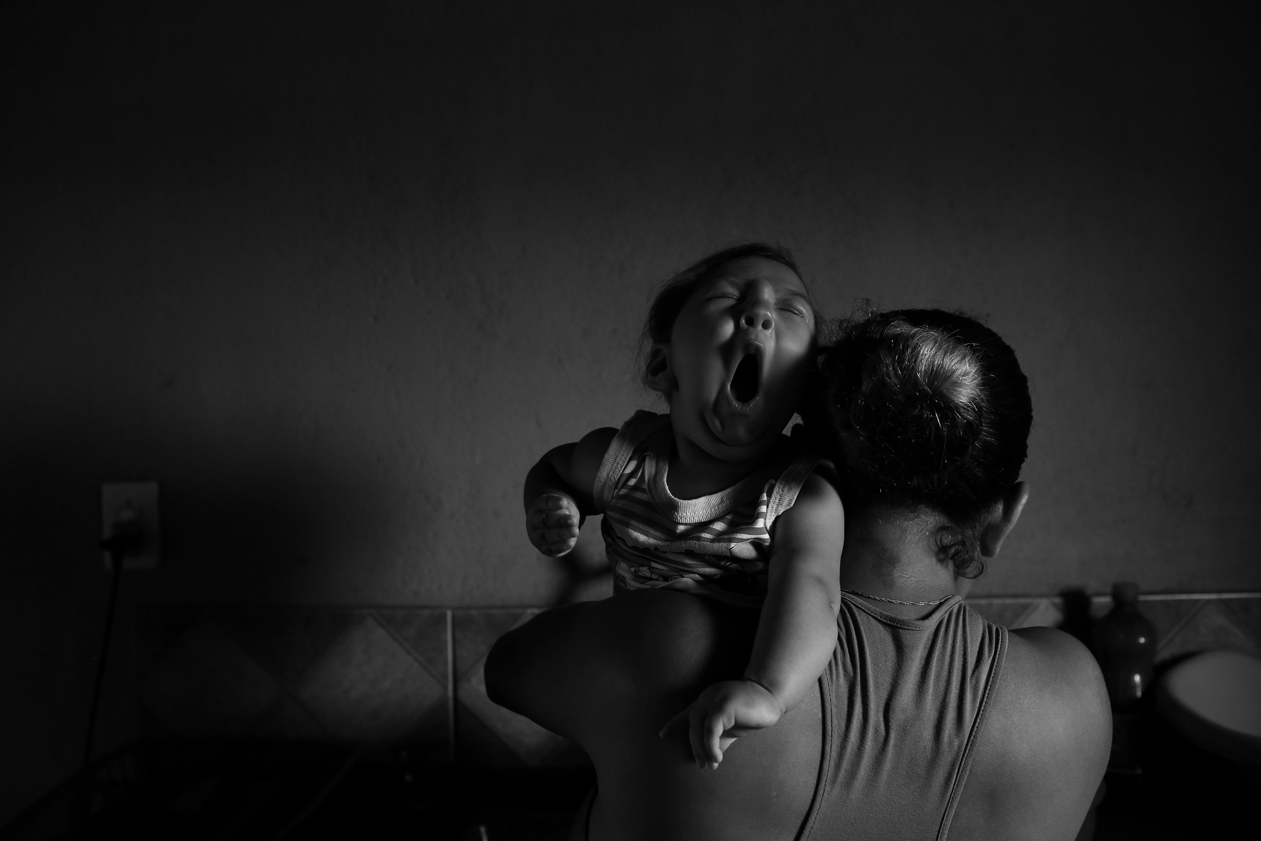  Juggling her tired son Gilberto, who was born with microcephaly, single mother Josemary Gomes, age 34, cleans dishes at her kitchen sink. Gilberto must constantly be held or he will start crying again; babies with microcephaly tend to be more easily