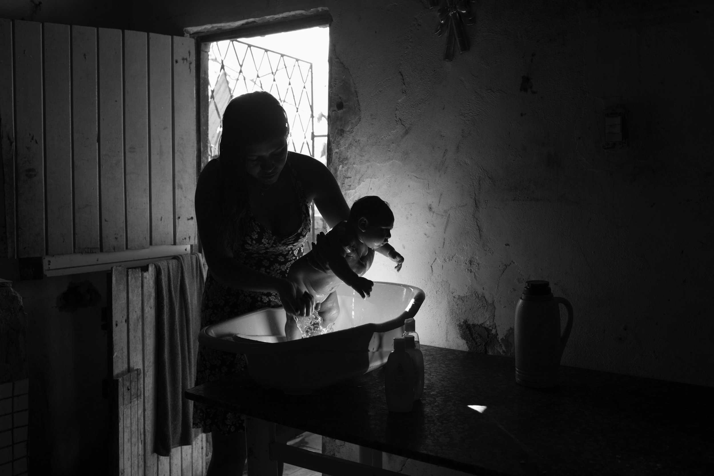  Samuel Amorim, 2 months, who was born with microcephaly, is bathed by a family member in the kitchen of the family’s home in an impoverished neighborhood of Campina Grande, Brazil. Their neighborhood, which does not have running water for three days