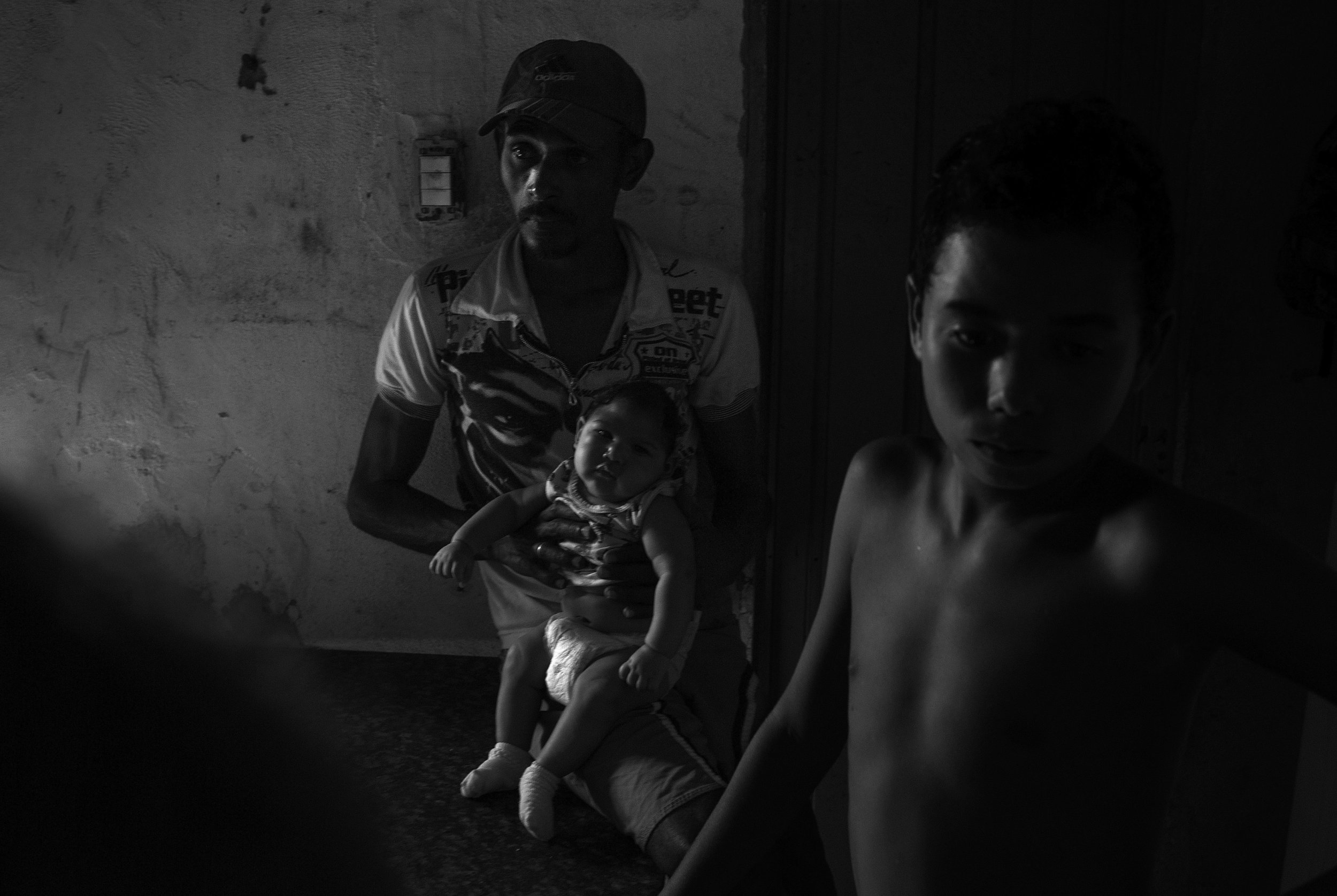 Alexandre Santiago holds his son, Samuel Amorim, who was born with microcephaly, in their home in one of Campina Grande’s poorest neighborhoods. Before Samuel was born, Alexandre and his wife, Alessandra de Sousa Amorim, both worked outside of the h