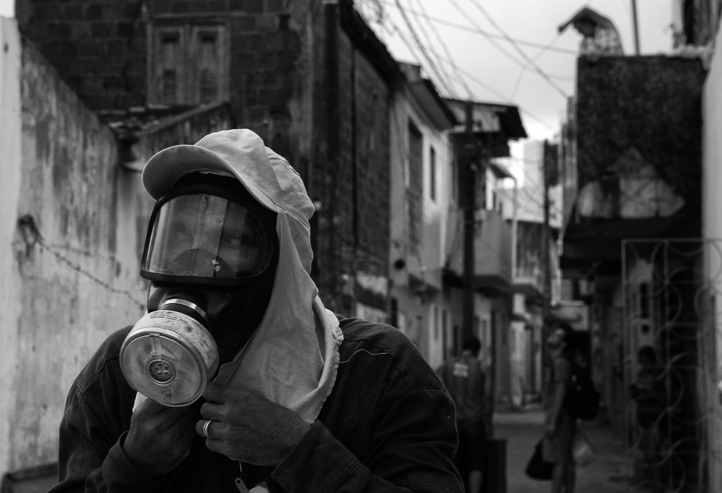  After fumigating a neighborhood in an attempt to eradicate the mosquito that causes the Zika virus, a health worker with Campina Grande's Municipal Health Department prepares to remove his gas mask.&nbsp; With no vaccine or treatment for Zika, Brazi