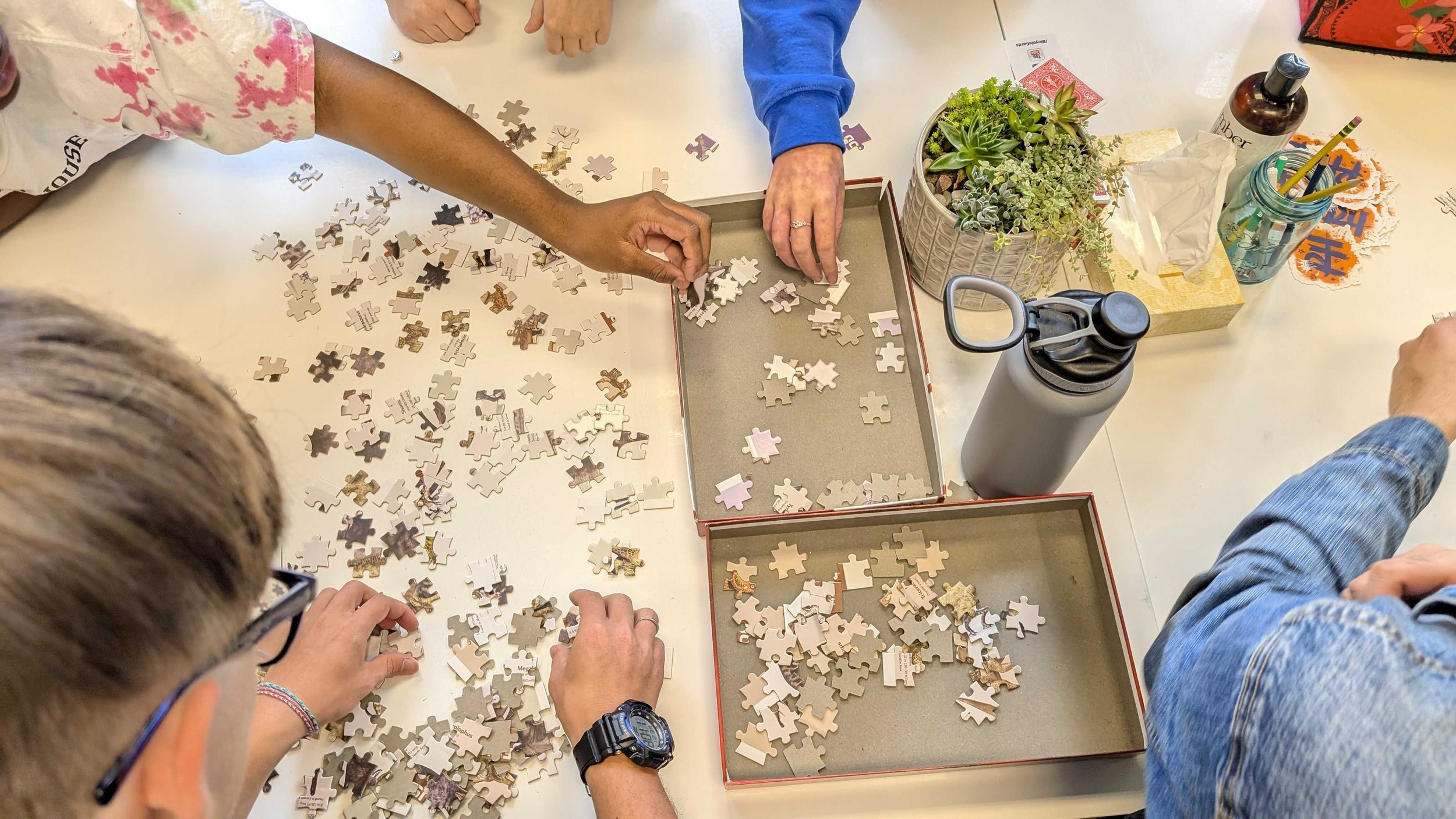A big feature of the first day of school is building belonging -- here, an advisory group gets to know each other by working on a puzzle together.