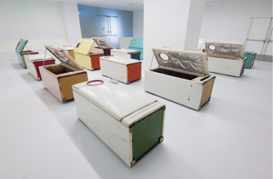 Malcolm Cochran, Requiem (2018). Refrigerators (carpeting, upholstery, pigmented wax, interior lighting, rubber hose, audio speakers) fluorescent lighting, perimeter benches, solo, a capella vocalises, pre-recorded and preformed live on March 18th, 2018. Photo courtesy of Tony Walsh.