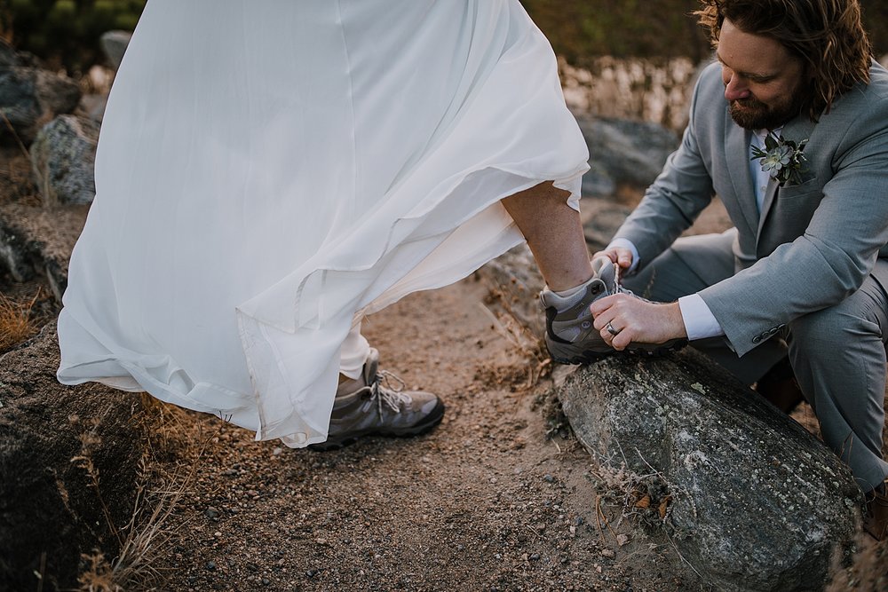 groom tying brides shoes, sprague lake dock elopement, sunrise elopement, colorado elopement, sprague lake elopement, rocky mountain national park elopement, adventurous colorado hiking elopement