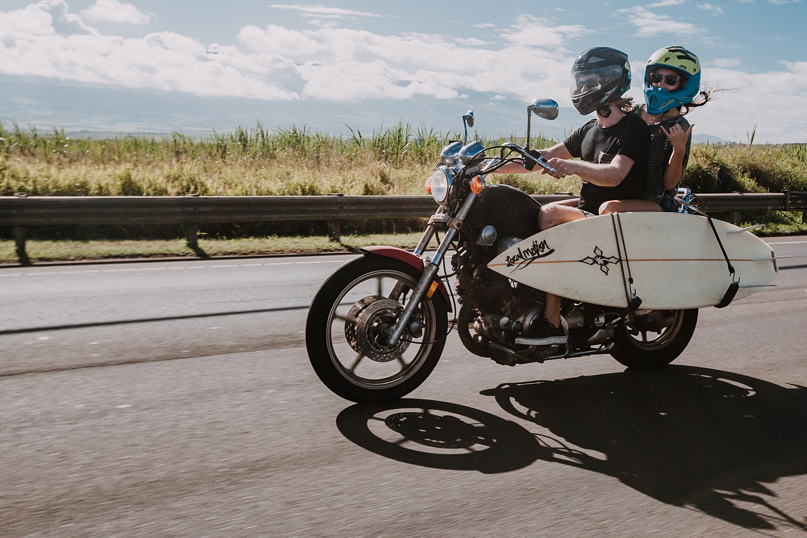 couple riding motorcycle with surfboard in maui hawaii, surfboard on a motorcyle, maui hawaii engagements, maui hawaii elopement, paia surfing, motorcycle engagements