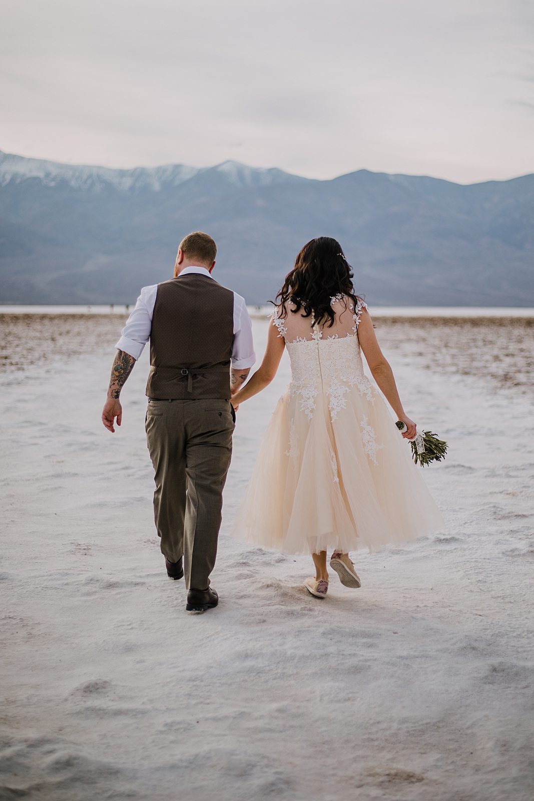 couple hiking the salt flats, death valley national park elopement, elope in death valley, badwater basin elopement, hiking in death valley national park, sunset at badwater basin