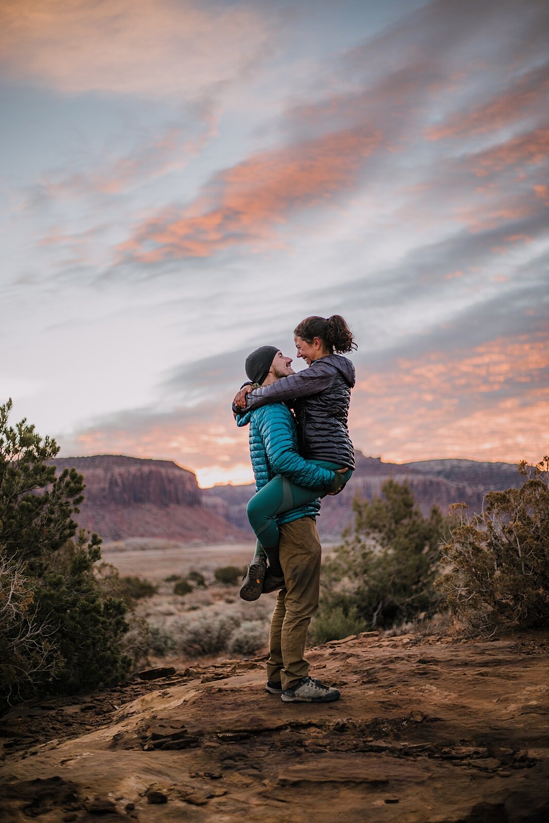 couple hiking through the desert, indian creek climbing area, canyonlands national park, moab utah engagements, sunrise in moab utah