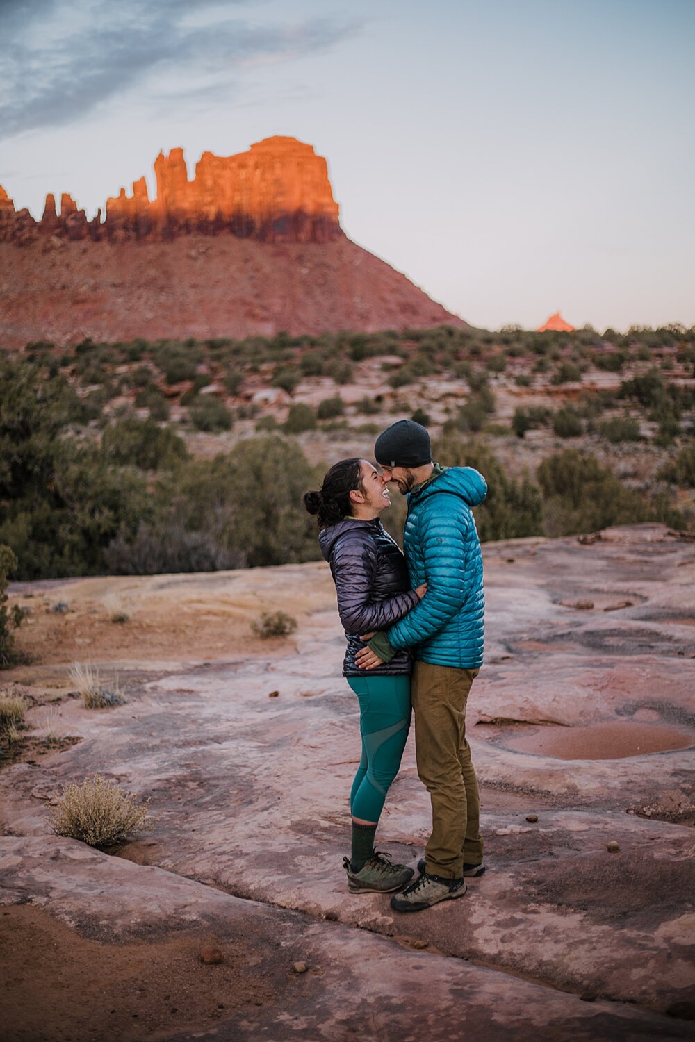 couple hiking through indian creek near monticello utah, indian creek climbing area, canyonlands national park, moab utah engagements, sunrise in moab utah