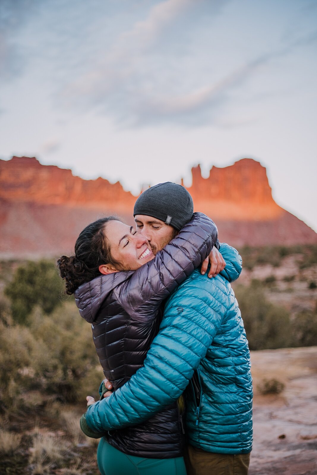 couple hugging in indian creek near monticello utah, indian creek climbing area, canyonlands national park, moab utah engagements, sunrise in moab utah
