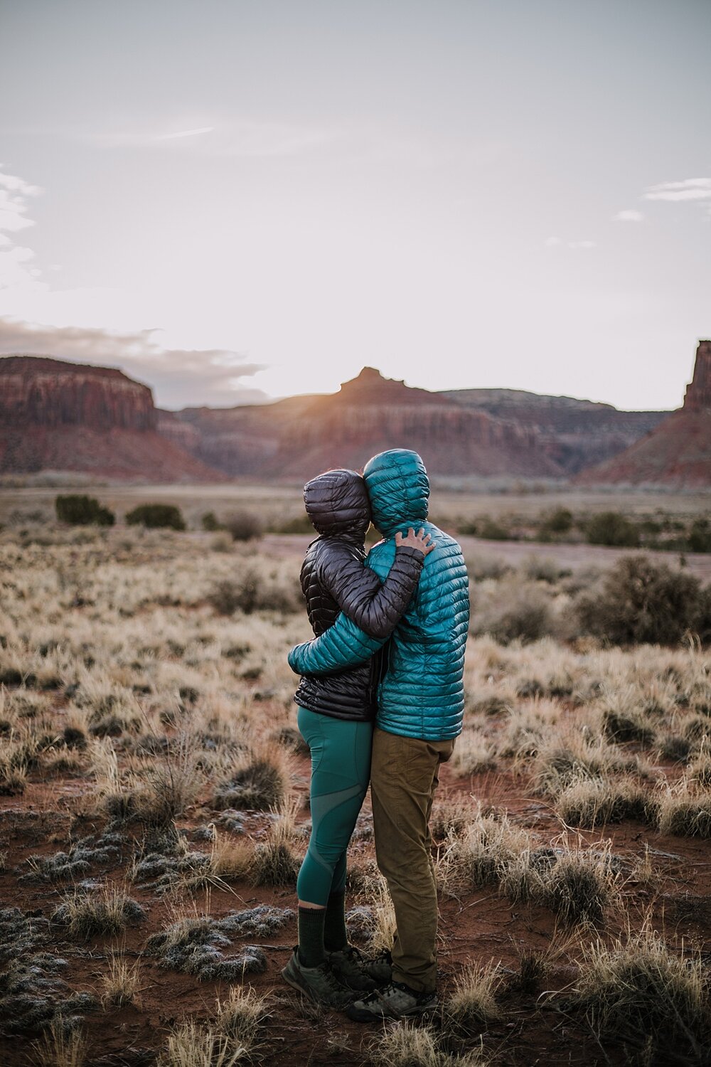 couple hiking through indian creek near monticello utah, indian creek climbing area, canyonlands national park, moab utah engagements, sunrise in moab utah