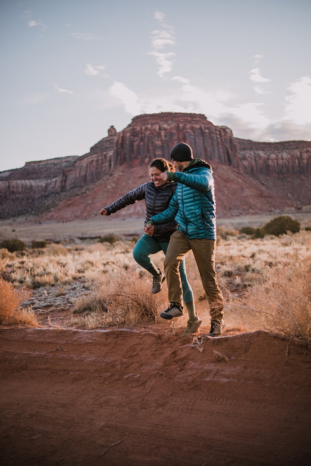 couple jumping in indian creek near monticello utah, indian creek climbing area, canyonlands national park, moab utah engagements, sunrise in moab utah