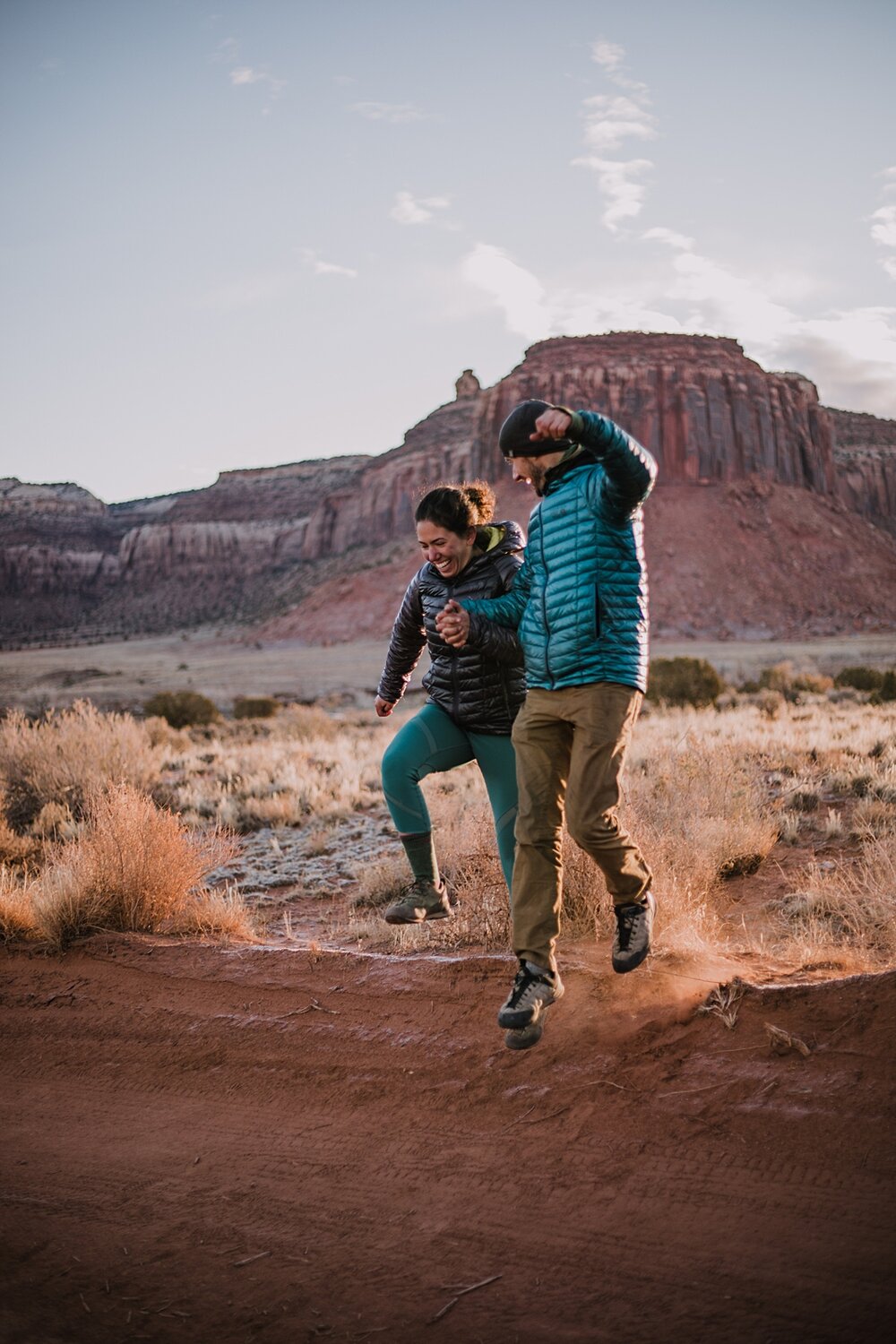 couple jumping indian creek near monticello utah, indian creek climbing area, canyonlands national park, moab utah engagements, sunrise in moab utah