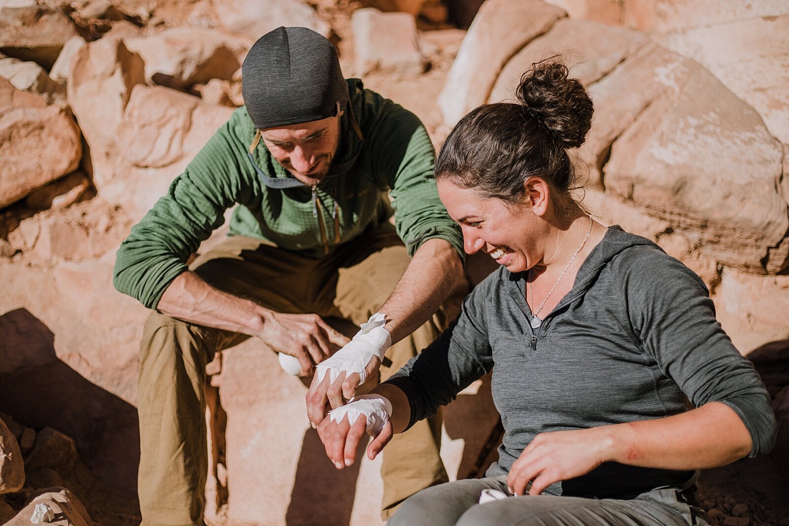 couple making tape gloves in indian creek near monticello utah, indian creek climbing area, canyonlands national park, moab utah climbing engagements, crack climbing moab utah
