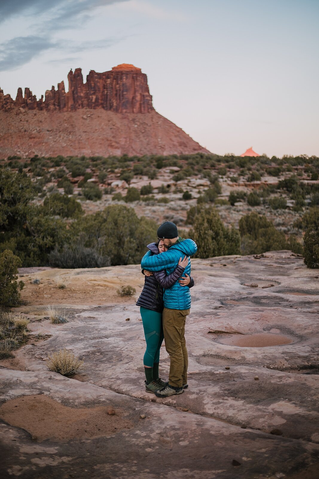 couple hugging in indian creek, indian creek climbing area, canyonlands national park, moab utah engagements, sunrise in moab utah