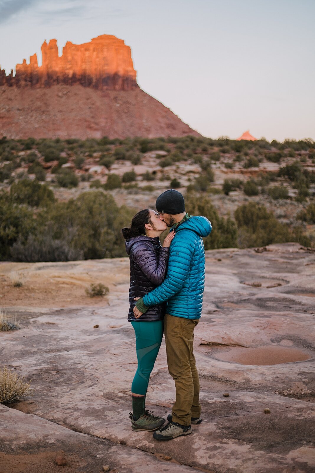 couple cuddling in indian creek, indian creek climbing area, canyonlands national park, moab utah engagements, sunrise in moab utah