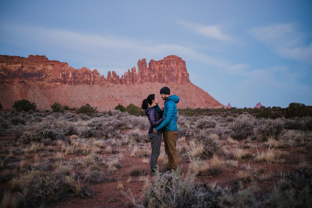 couple bathed in alpine glow at indian creek, indian creek climbing area, canyonlands national park, moab utah engagements, sunrise in moab utah