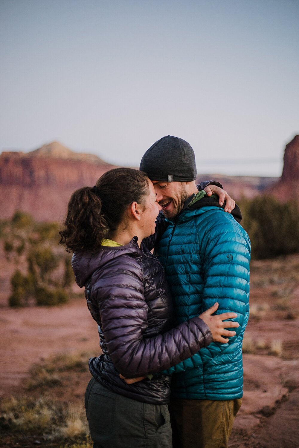 couple hiking during sunrise alpine glow at indian creek, indian creek climbing area, canyonlands national park, moab utah engagements, sunrise in moab utah