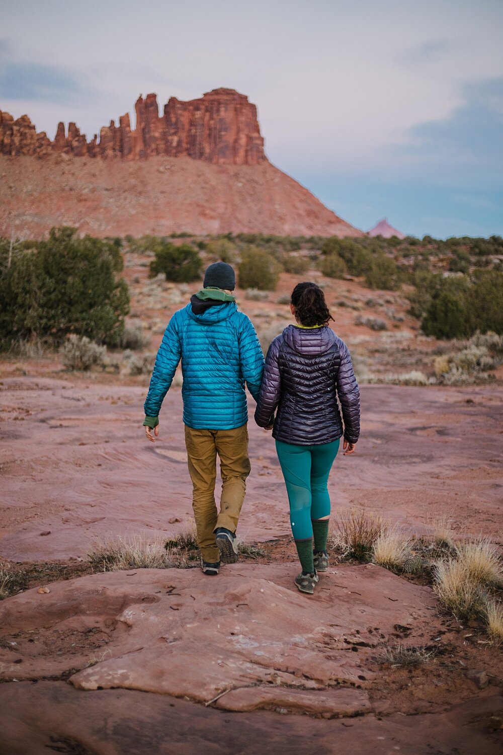 couple hiking during sunrise alpine glow at indian creek, indian creek climbing area, canyonlands national park, moab utah engagements, sunrise in moab utah