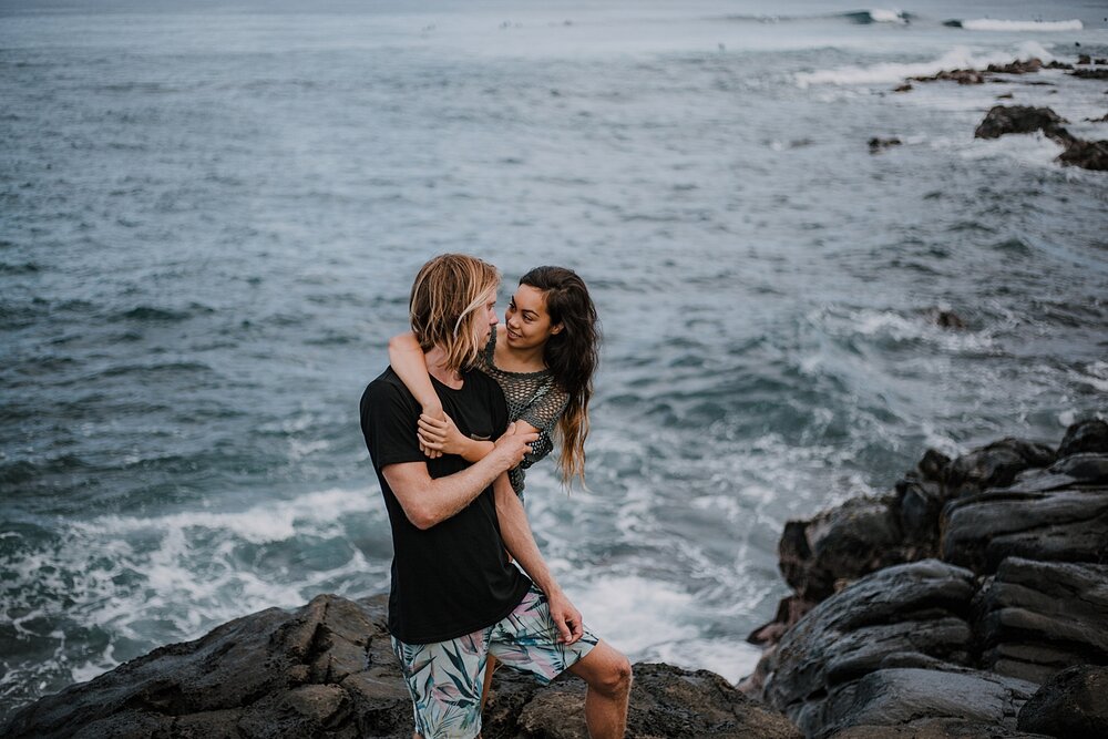 couple standing on lava rocks on ho'okipa beach, couple hiking ho'okipa, maui hawaii photographer, maui hawaii surfing, surfing at ho'okipa beach, ho'okipa beach engagements, motorcycle engagements