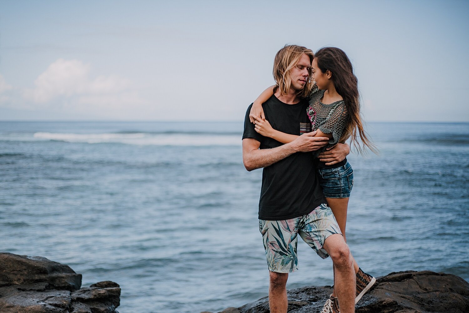 couple standing on lava rocks on ho'okipa beach, couple hiking ho'okipa, maui hawaii photographer, maui hawaii surfing, surfing at ho'okipa beach, ho'okipa beach engagements, motorcycle engagements