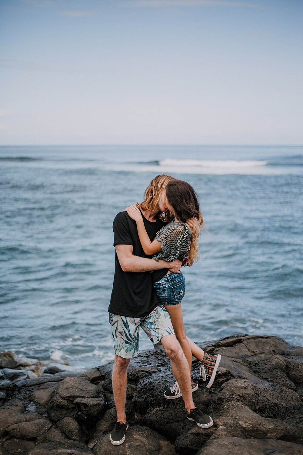 couple standing on lava rocks on ho'okipa beach, couple hiking ho'okipa, maui hawaii photographer, maui hawaii surfing, surfing at ho'okipa beach, ho'okipa beach engagements, motorcycle engagements