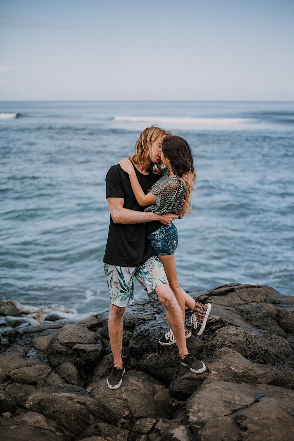 couple standing on lava rocks on ho'okipa beach, couple hiking ho'okipa, maui hawaii photographer, maui hawaii surfing, surfing at ho'okipa beach, ho'okipa beach engagements, motorcycle engagements