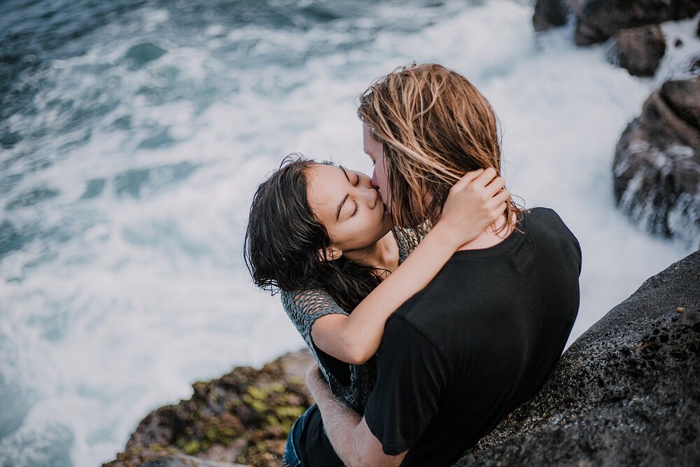 kissing on volcanic lava rocks on ho'okipa beach, couple hiking ho'okipa, maui hawaii photographer, maui hawaii surfing, surfing at ho'okipa beach, ho'okipa beach engagements, motorcycle engagements