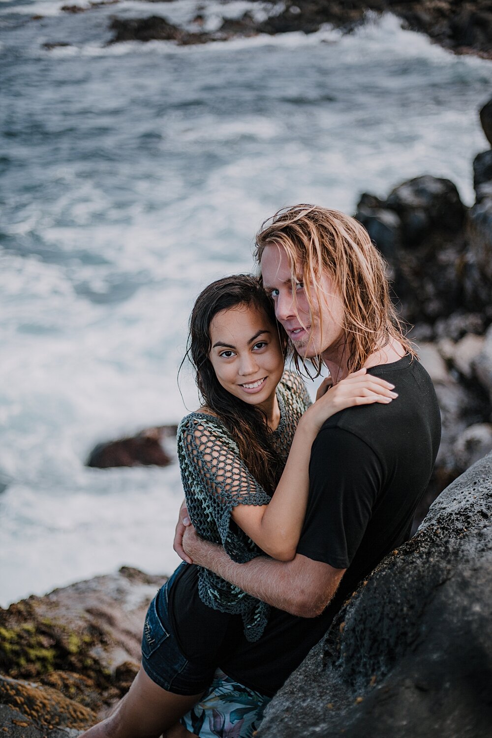kissing on volcanic lava rocks on ho'okipa beach, couple hiking ho'okipa, maui hawaii photographer, maui hawaii surfing, surfing at ho'okipa beach, ho'okipa beach engagements, motorcycle engagements