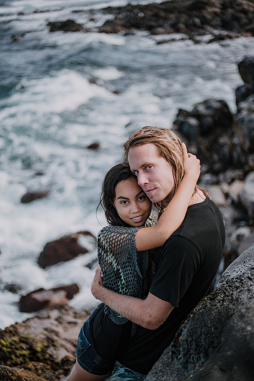 kissing on volcanic lava rocks on ho'okipa beach, couple hiking ho'okipa, maui hawaii photographer, maui hawaii surfing, surfing at ho'okipa beach, ho'okipa beach engagements, motorcycle engagements