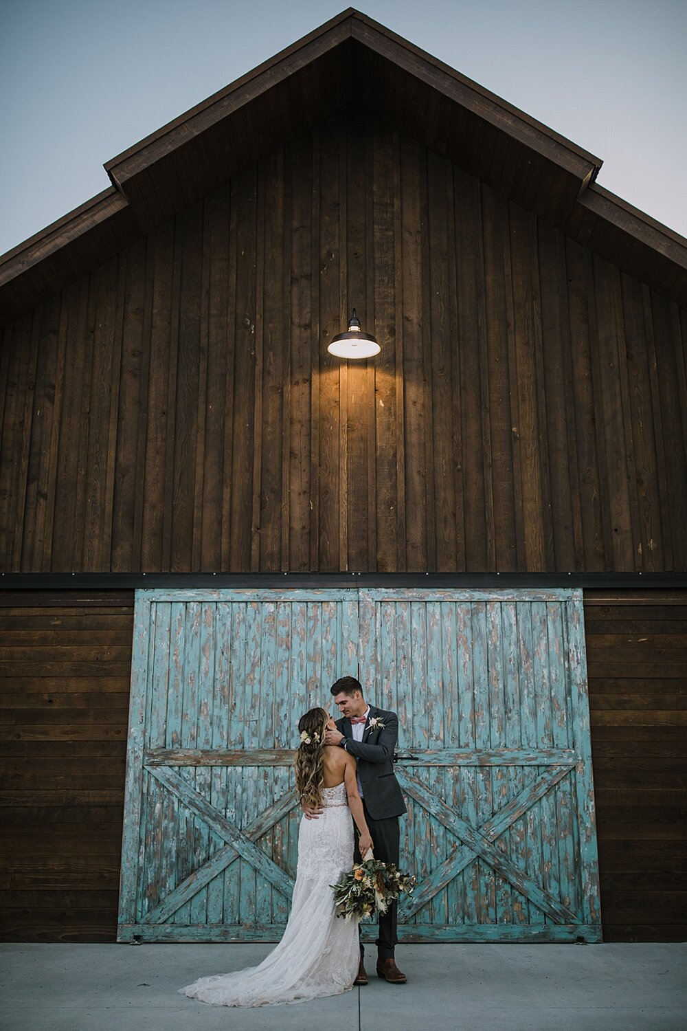 bride and groom in front of barn doors, the barn at sunset ranch in buena vista co, buena vista colorado wedding, the barn at sunset ranch wedding, buena vista colorado wood barn rustic wedding venue