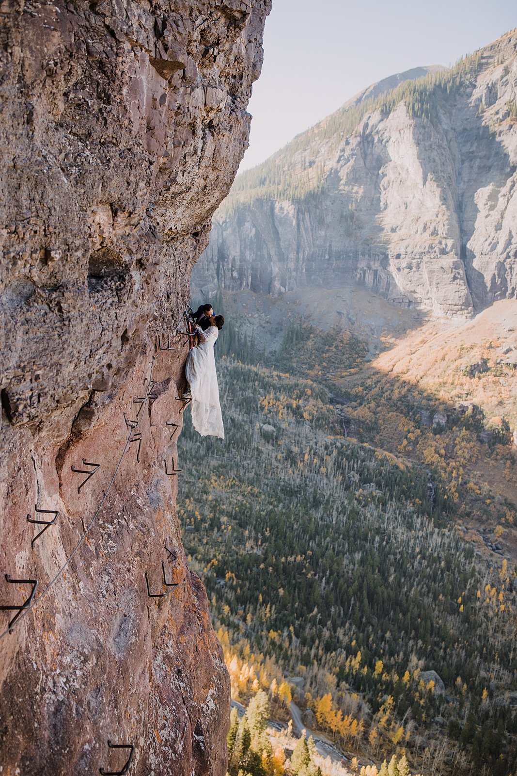 bride and groom eloping on a cliff edge, eloping on the via ferrata's main event, rocky mountain range climbing, hiking the telluride via ferrata trail, high alpine mountaineering elopement